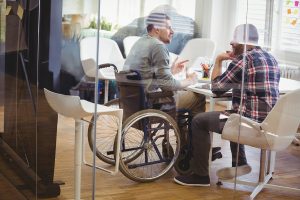 Full length of handicap businessman discussing with colleague in